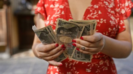 Photo for Young woman's hands, busy counting yen banknotes in the traditional streets of kyoto, a caucasian immersed in japanese banking and finance - Royalty Free Image