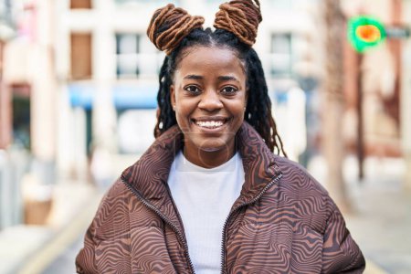 Foto de Mujer afroamericana sonriendo confiada de pie en la calle - Imagen libre de derechos