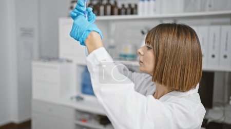 Photo for Captivating young hispanic woman scientist, admiring test tubes in the heart of her laboratory, engulfed in the art of science and research - Royalty Free Image