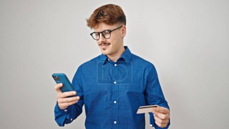 Téléchargez les photos : Jeune homme hispanique utilisant smartphone et carte de crédit sur fond blanc isolé - en image libre de droit