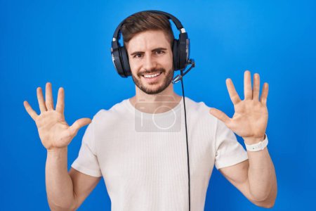 Photo for Hispanic man with beard listening to music wearing headphones showing and pointing up with fingers number ten while smiling confident and happy. - Royalty Free Image