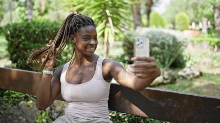 Photo for African american woman make selfie by smartphone sitting on bench at park - Royalty Free Image