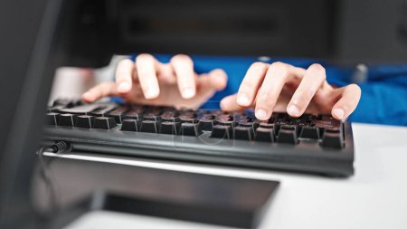 Téléchargez les photos : Jeune homme hispanique utilisant l'ordinateur tapant sur le clavier au bureau - en image libre de droit
