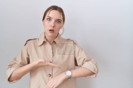 Téléchargez les photos : Jeune femme caucasienne portant une chemise décontractée à la hâte pointant vers regarder le temps, l'impatience, contrarié et en colère pour retard de délai - en image libre de droit