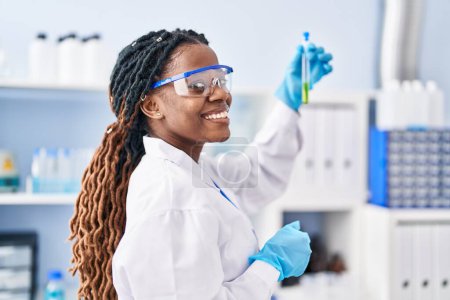 Foto de African american woman scientist holding test tube at laboratory - Imagen libre de derechos
