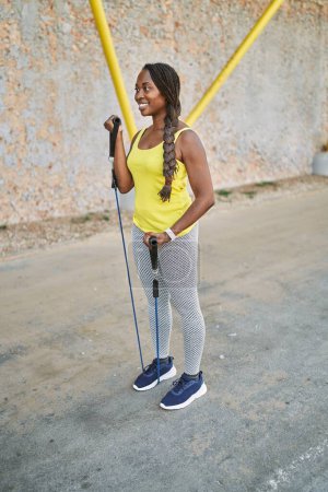 Photo for African american woman using elastic band training at street - Royalty Free Image