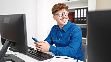 Téléchargez les photos : Jeune homme hispanique travailleur d'affaires en utilisant smartphone souriant au bureau - en image libre de droit