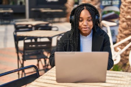 Photo for African american woman having video call sitting on table at coffee shop terrace - Royalty Free Image