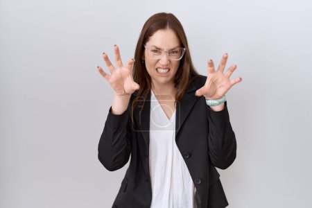 Photo for Beautiful brunette woman wearing business jacket and glasses smiling funny doing claw gesture as cat, aggressive and sexy expression - Royalty Free Image