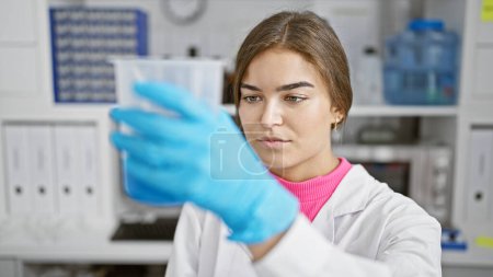 Photo for Portrait of a dedicated young hispanic woman, a beautiful scientist, diligently measuring liquid in a lab as part of her biology research work, embodying the graceful blend of beauty and science. - Royalty Free Image