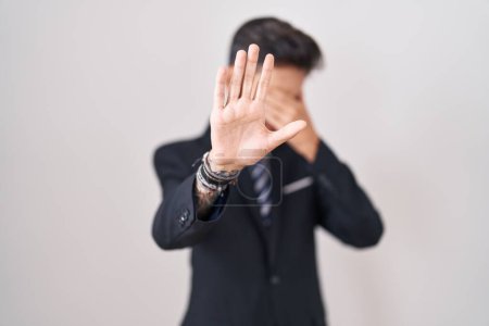 Photo for Young hispanic man with tattoos wearing business suit and tie covering eyes with hands and doing stop gesture with sad and fear expression. embarrassed and negative concept. - Royalty Free Image