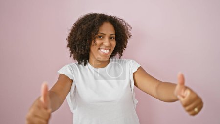 Téléchargez les photos : Femme afro-américaine avec les pouces vers le haut isolé sur fond rose - en image libre de droit