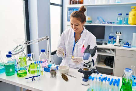 Photo for Young beautiful hispanic woman scientist smiling confident holding syrup at laboratory - Royalty Free Image