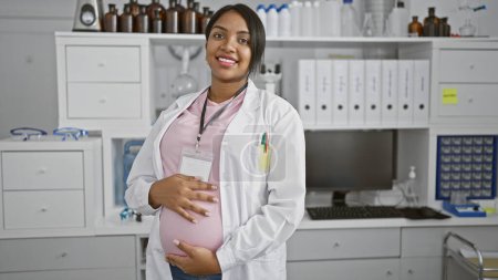 Photo for Expecting scientist, young, pregnant woman, smiling while touching her belly, amidst medical research in laboratory - Royalty Free Image