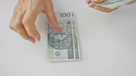 Téléchargez les photos : Gros plan des mains féminines comptant les billets en zloty polonais, symbolisant les transactions financières en poland. - en image libre de droit