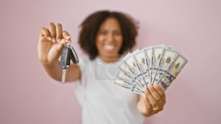 Téléchargez les photos : Femme afro-américaine avec des clés de voiture et de l'argent sur fond rose - en image libre de droit
