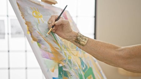 Téléchargez les photos : Main de femme artiste senior dessinant gracieusement sur toile dans un atelier d'art, une leçon de créativité pour les étudiants matures de l'académie locale - en image libre de droit