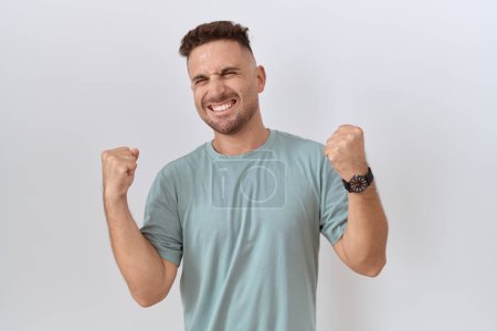 Photo for Hispanic man with beard standing over white background celebrating surprised and amazed for success with arms raised and eyes closed. winner concept. - Royalty Free Image