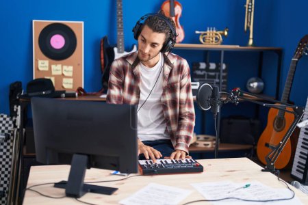 Téléchargez les photos : Young hispanic man musician having dj session at music studio - en image libre de droit