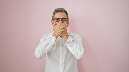 Photo for Wow! amazed young hispanic man with grey-haired expression, hands covering open mouth, standing over pink isolated background! - Royalty Free Image