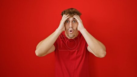 Photo for Oh wow! stunning portrait of a young, handsome hispanic man expressing incredible surprise, standing isolated over a vivid red background. - Royalty Free Image