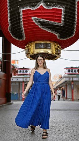 Photo for Beautiful hispanic woman donning glasses, flashing a cheerful smile at the senso-ji temple, immersed in japanese tradition, joyful latin adult exploring the rich culture of tokyo - Royalty Free Image