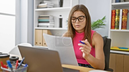 Photo for Young beautiful hispanic woman business worker reading document working at the office - Royalty Free Image