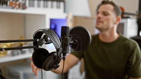Photo for Focused man with closed eyes feeling the music in a recording studio. - Royalty Free Image