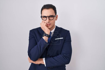 Photo for Young hispanic man wearing suit and tie looking stressed and nervous with hands on mouth biting nails. anxiety problem. - Royalty Free Image