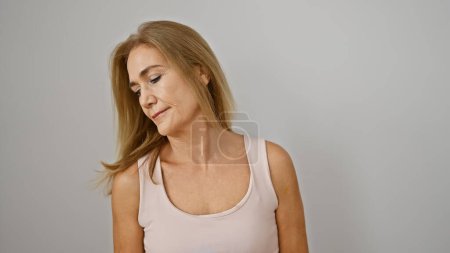 Foto de Mujer rubia madura contemplativa sobre un fondo blanco - Imagen libre de derechos