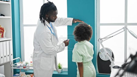 Téléchargez les photos : Médecin et patient ayant une consultation médicale mesurant la hauteur à la clinique - en image libre de droit