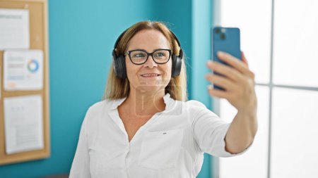 Photo for Middle age hispanic woman business worker make selfie picture by smartphone at the office - Royalty Free Image