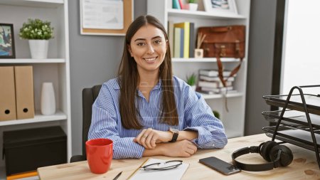 Foto de Retrato de una joven hispana sonriente en una oficina de negocios, usando atuendo profesional y accesorios. - Imagen libre de derechos