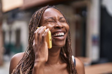 Foto de African american woman smiling confident talking on the smartphone at coffee shop terrace - Imagen libre de derechos