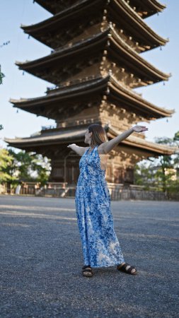Photo for Cheerful brunette hispanic woman welcoming joy with open arms, looking around beautiful to-ji temple, reveling in kyoto's tower beauty - Royalty Free Image
