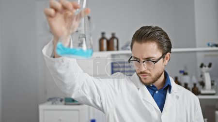 Photo for Young hispanic man scientist looking test tube at laboratory - Royalty Free Image