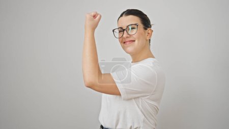 Téléchargez les photos : Jeune belle femme hispanique souriant confiant faire un geste fort avec les bras sur fond blanc isolé - en image libre de droit