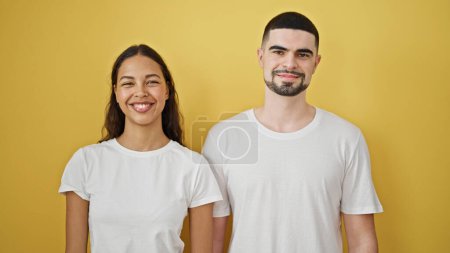 Photo for Cheerful and beautiful couple confidently smiling together, standing against a trendy yellow isolated background displaying happiness and love. - Royalty Free Image