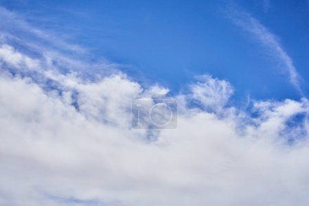 Téléchargez les photos : Un ciel serein parsemé de nuages pelucheux et de traînées de blanc, symbolisant tranquillité et immensité. - en image libre de droit