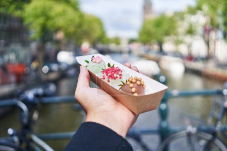 Téléchargez les photos : Main d'homme tenant boîte avec dessert au chocolat à Amsterdam - en image libre de droit