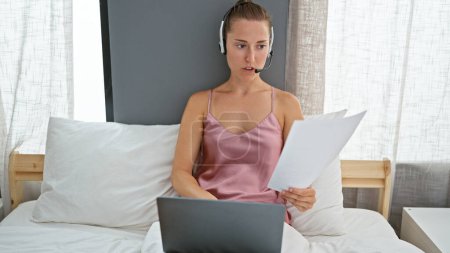 Photo for Young caucasian woman doing video call with laptop sitting on the bed at bedroom - Royalty Free Image