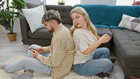 Photo for A couple sits back-to-back in their living room, clearly in disagreement, showing tension in their relationship. - Royalty Free Image