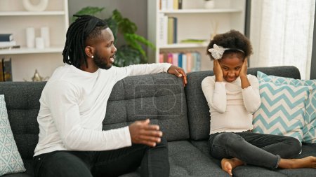 Photo for African american father and daughter sitting on sofa arguing at home - Royalty Free Image