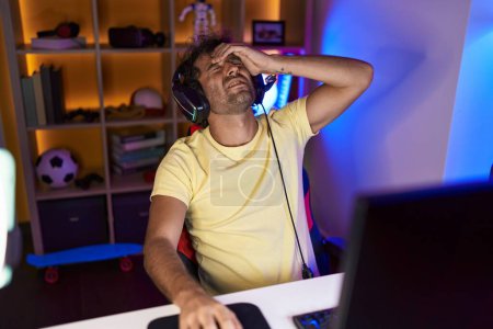 Foto de Joven streamer hispano estresado usando computadora en sala de juegos - Imagen libre de derechos