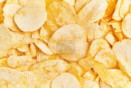 Photo for Top view of a full-frame background of crispy golden potato chips, perfect for snack or food themes. - Royalty Free Image