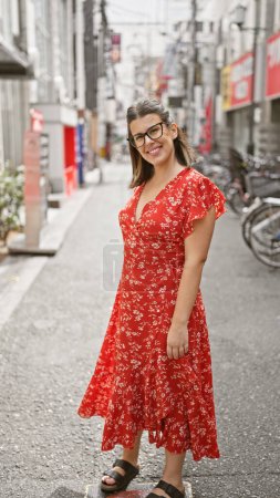 Téléchargez les photos : Joyeux hispanique femme clignotant un sourire gagnant sur les rues osaka - en image libre de droit