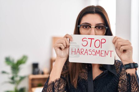 Téléchargez les photos : Young beautiful hispanic woman business worker holding stop harassment message banner at office - en image libre de droit