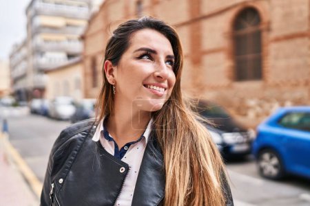 Foto de Young beautiful hispanic woman smiling confident looking to the side at street - Imagen libre de derechos