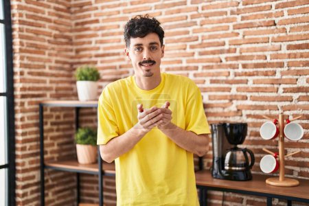 Téléchargez les photos : Young caucasian man holding cup of coffee standing at home - en image libre de droit