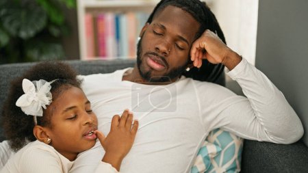 Téléchargez les photos : Père et fille afro-américains couchés sur le canapé dormant à la maison - en image libre de droit